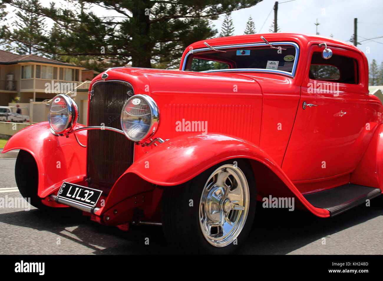 Una più grande di vita luminose red hot rod rotola leggermente lungo strade yamba nell'annuale hot rod show.mostrare i proprietari capolavoro in restauro. Foto Stock