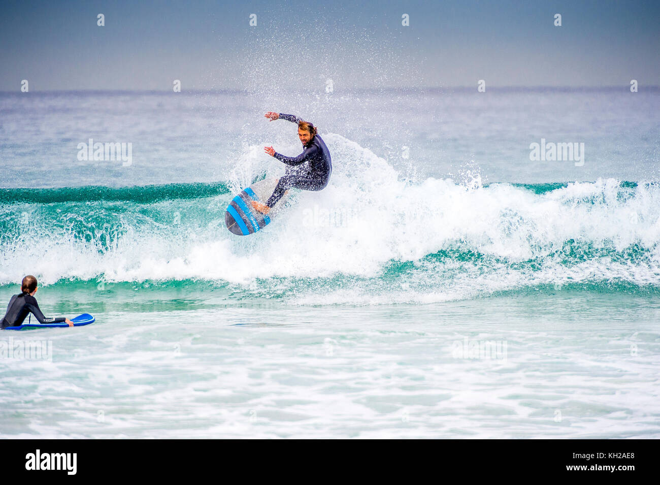 Un surfista cavalcare un onda a Sydney iconici Bondi Beach, NSW, Australia Foto Stock