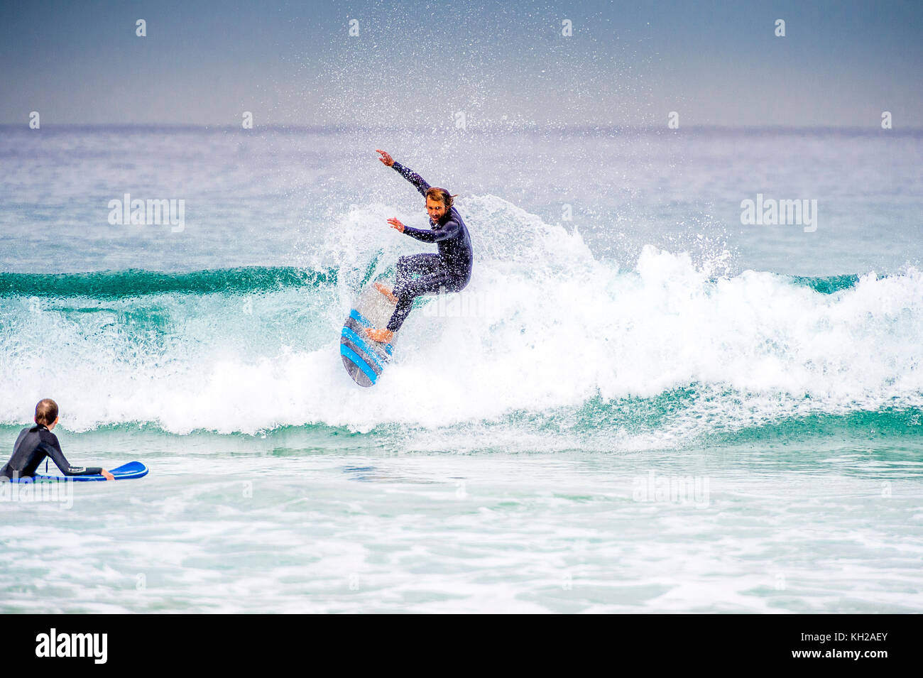 Un surfista cavalcare un onda a Sydney iconici Bondi Beach, NSW, Australia Foto Stock