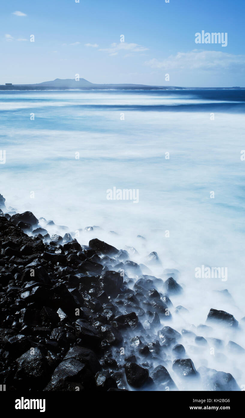 Tempo di esposizione lungo del mare e rocce laviche in corrispondenza di una posizione vicino a Los Hervideros, Lanzarote, Isole Canarie, Spagna Foto Stock