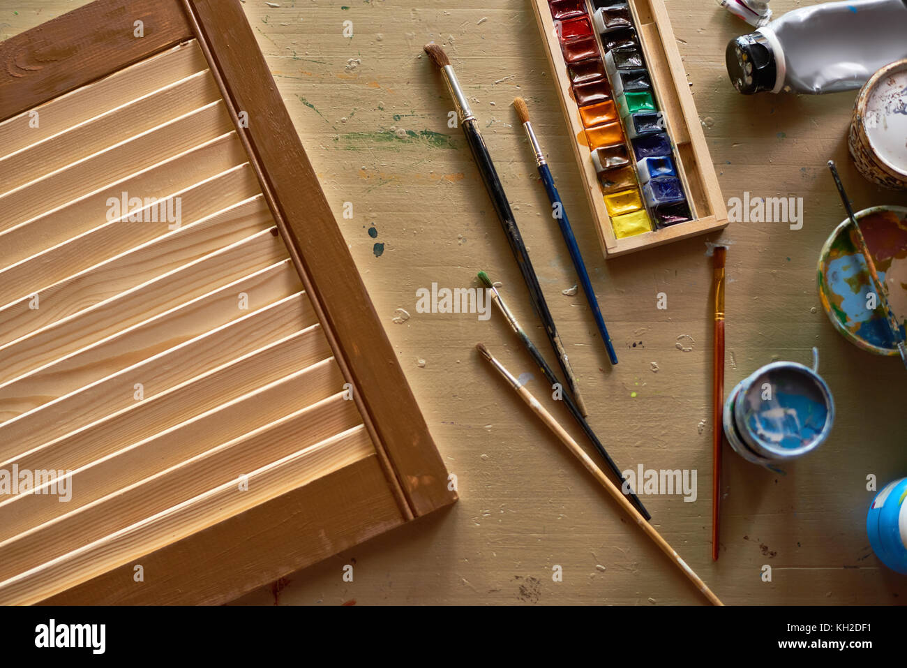 Vista sopra lo sfondo della workstation artisti preparati per DIY art project con spazzole, vernici e fornisce su un tavolo di legno Foto Stock