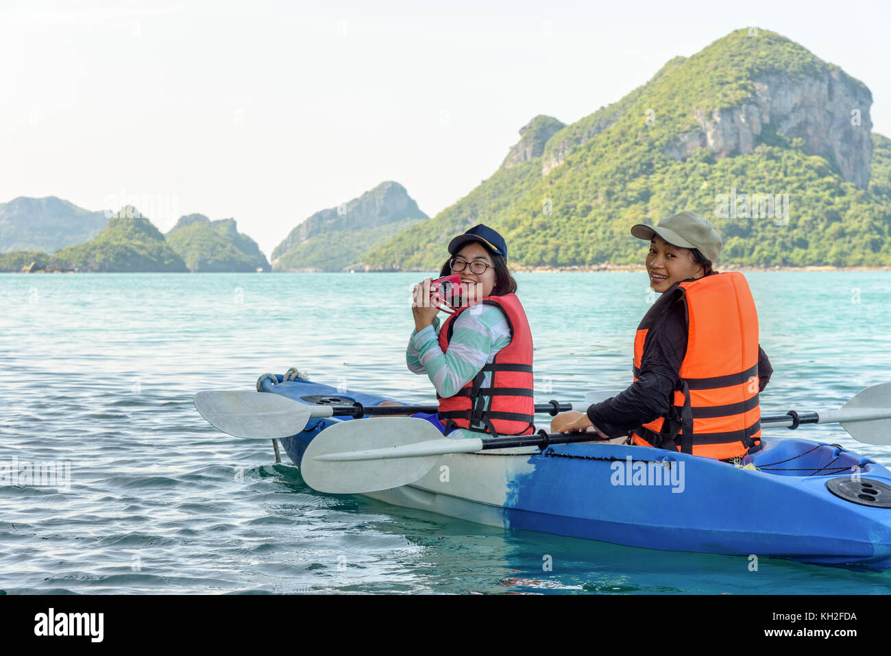 Due donne sono madre e figlia utilizzando una fotocamera per scattare foto sul kayak durante il viaggio in barca con felice sul mare durante il periodo estivo a ko Wua Ta Lap isla Foto Stock