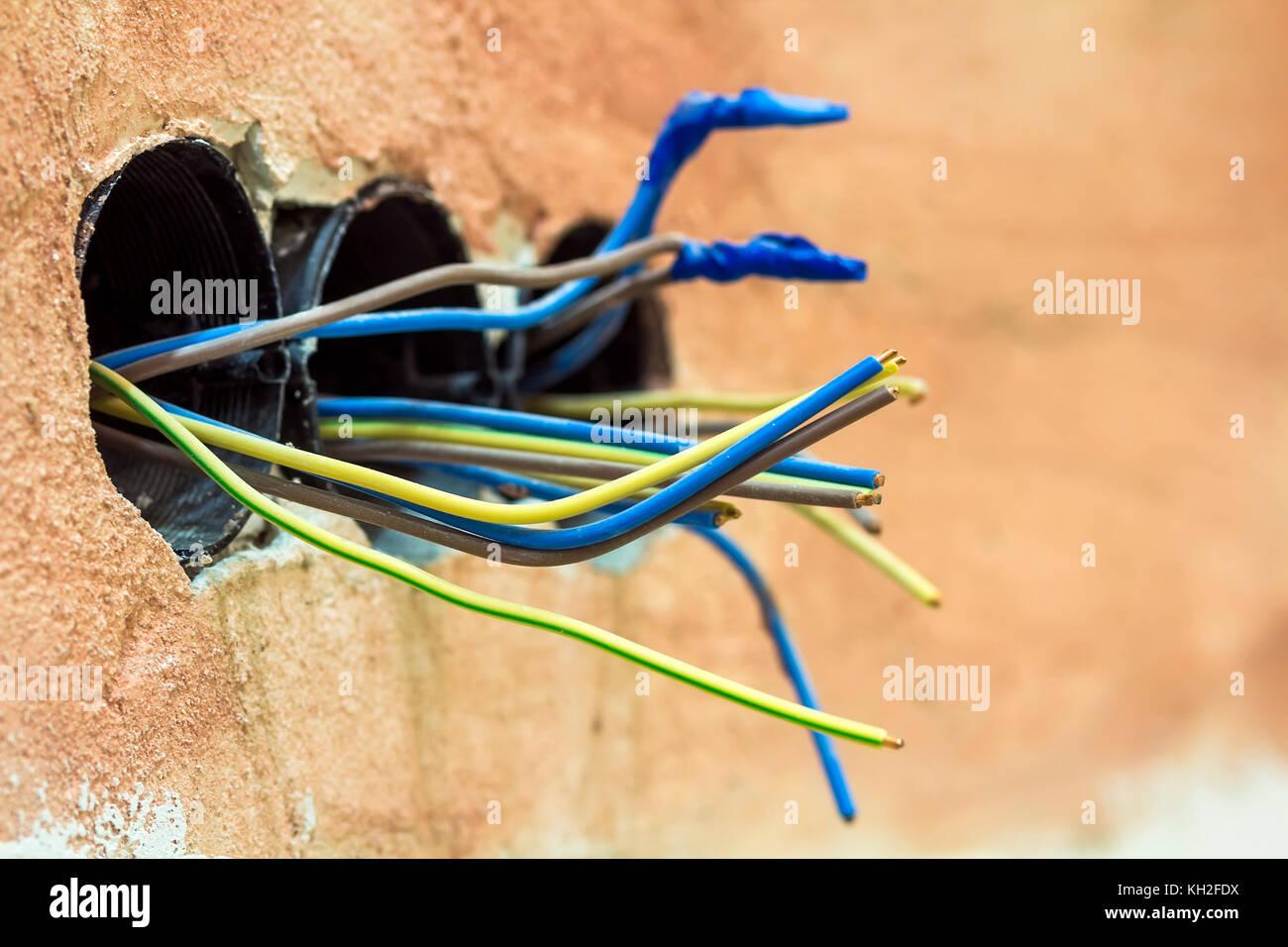 Opere di finitura a appartamento ristrutturato. cablaggio elettrico di installazione elettrica. fili esposti sporgente dalla presa sul vecchio muro Foto Stock