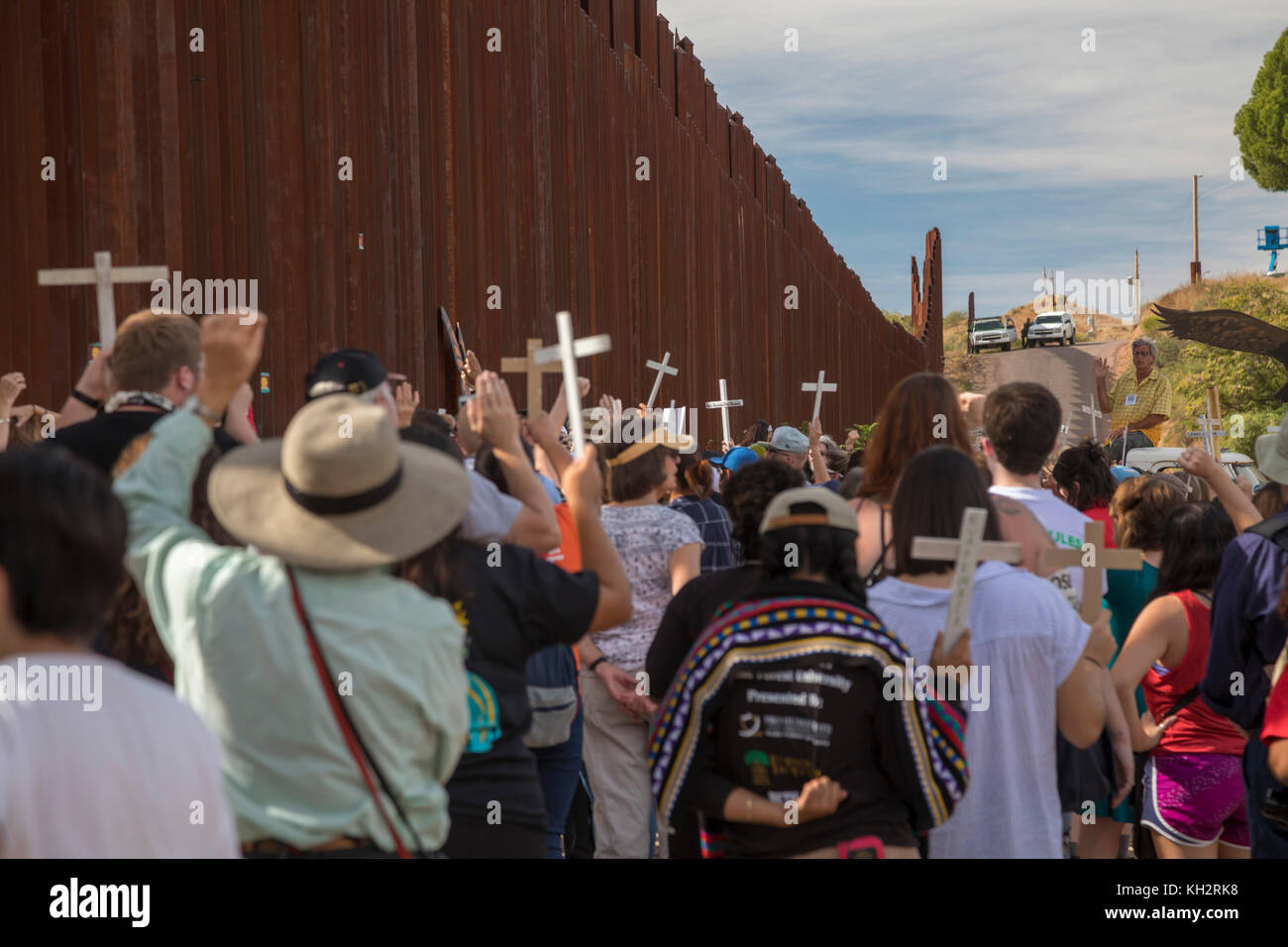 Nogales Arizona, Stati Uniti d'America - 12 novembre 2017 - un rally si tiene su entrambi i lati degli Stati Uniti-Messico recinzione di confine ricorda i migranti che sono morti nel tentativo di attraversare il confine. Pattuglia di Confine camion guardare il rally dalla cima della collina. Il rally è stato organizzato dalla Scuola delle Americhe guardare, un gruppo di religiosi e di comunità attivisti. Credito: jim west/alamy live news Foto Stock