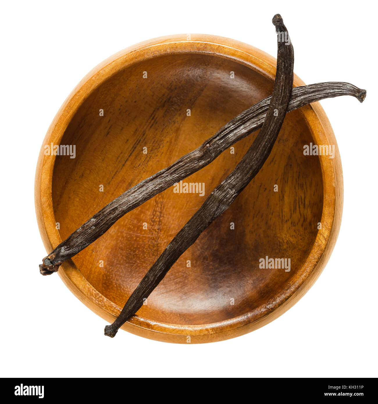 Essiccato borbone baccelli di vaniglia su vuoto ciotola di legno. Due marrone scuro frutti maturi di Vanilla planifolia. spice con un sapore particolare usato nella cottura in forno. Foto Stock