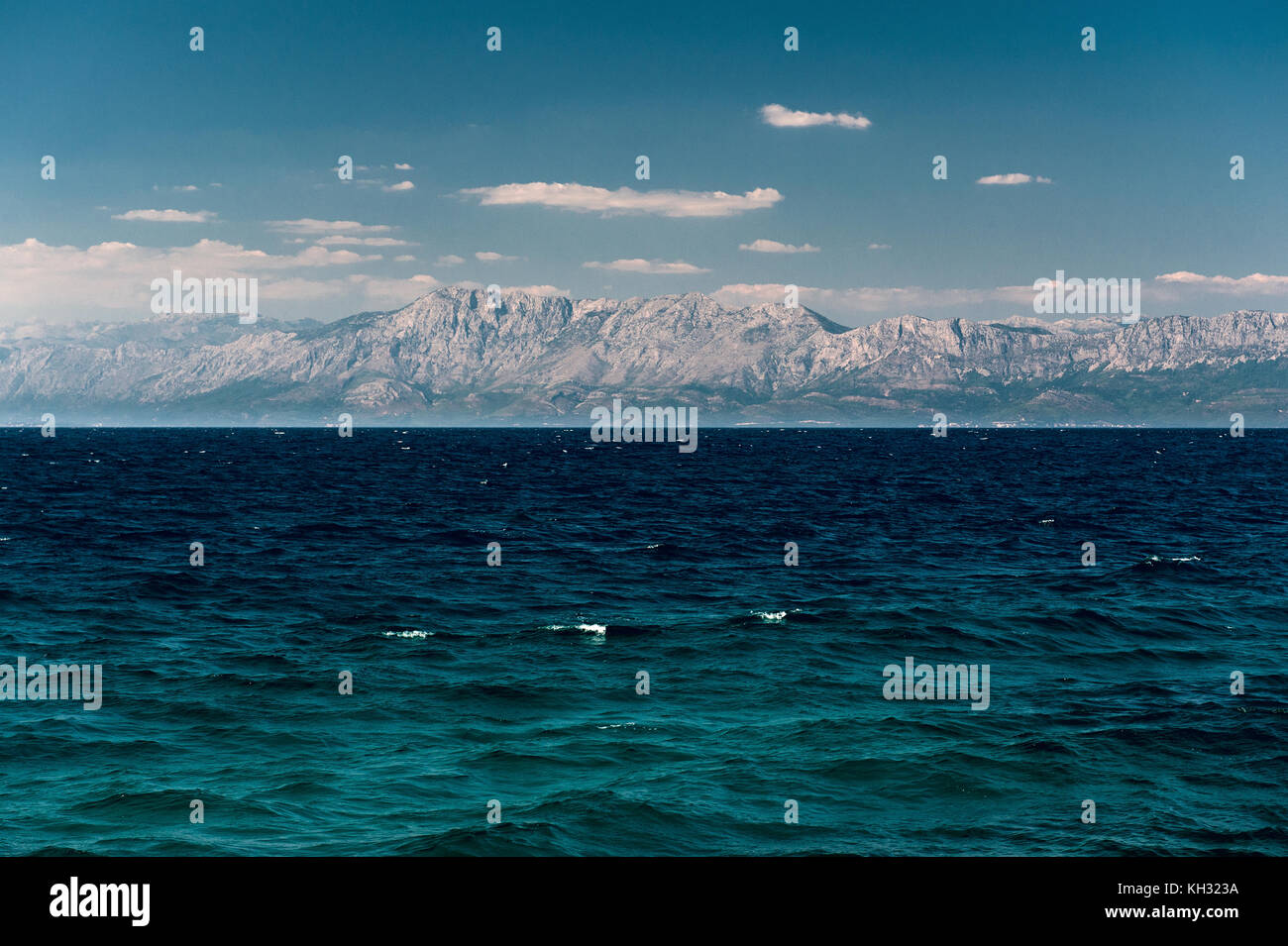 Montagne di pietra dietro il mare Adriatico il mare blu profondo Foto Stock