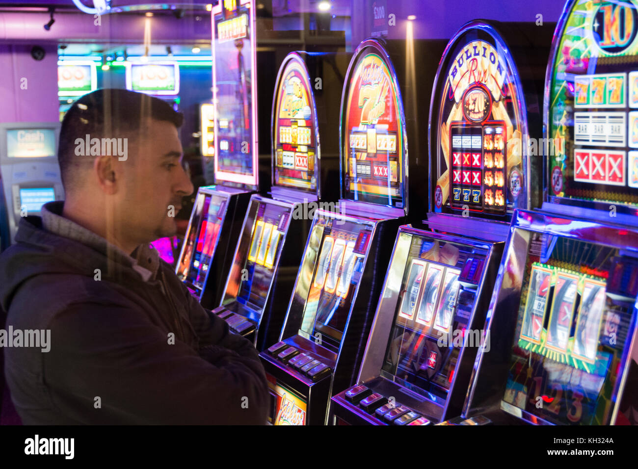 Un uomo gioca slot machines in una sala giochi a Chinatown nel West End di Londra, Regno Unito Foto Stock