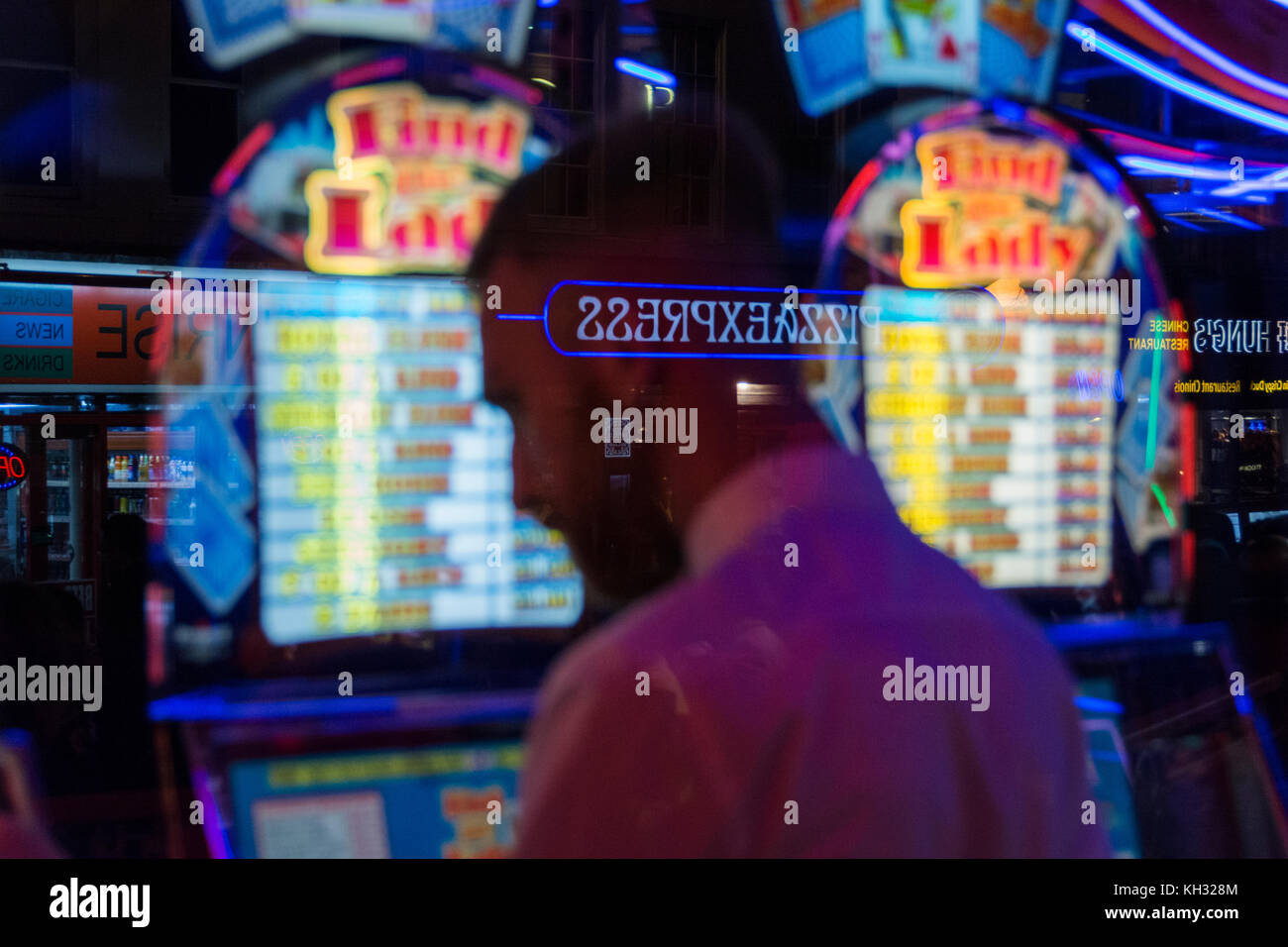 Un uomo gioca slot machines in una sala giochi a Chinatown in Soho nel West End di Londra, Regno Unito Foto Stock