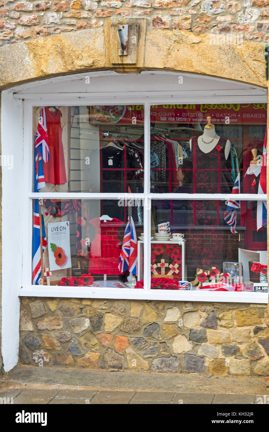 Negozio di carità finestra frontale con semi di papavero merchandise a sostegno del giorno del ricordo a Axminster, Devon, Inghilterra, Regno Unito nel mese di novembre Foto Stock
