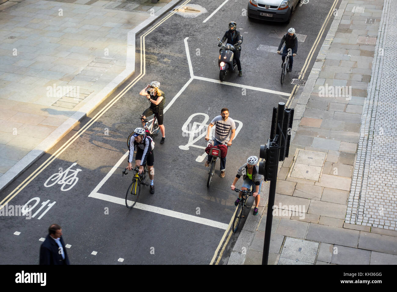 I ciclisti in attesa presso advanced linea di arresto (ASL), arresto avanzata box, box moto indicazioni stradali a segnalata nodo stradale a Londra, Regno Unito Foto Stock