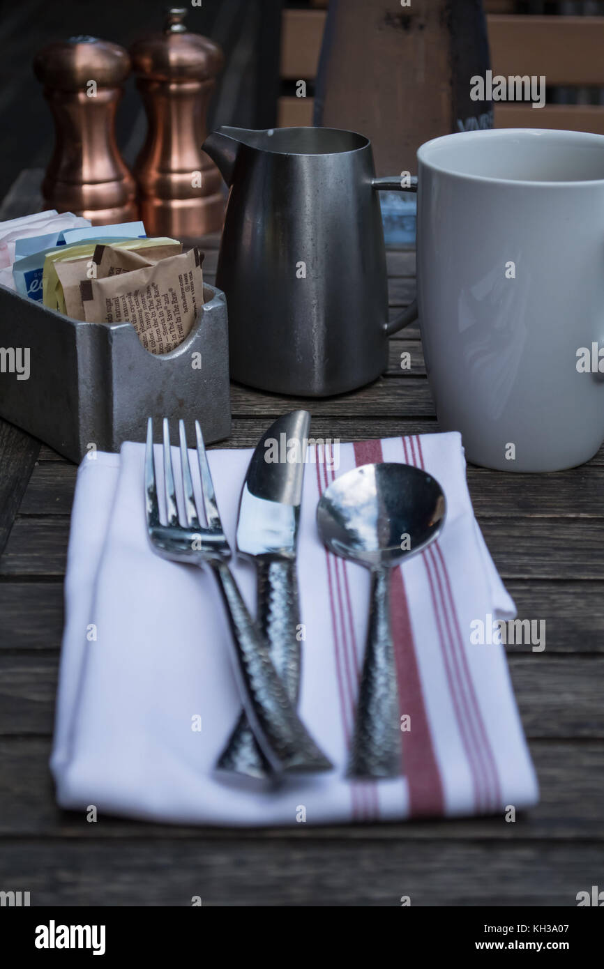 Pasti informali all'aperto - orientamento verticale con un primo piano del tavolo con tovaglioli e sacchetti di zucchero Foto Stock