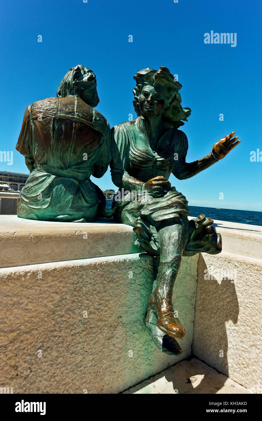 Le Sartine scultura in bronzo, le ragazze in maglia, sul lungomare. Uno dei simboli della città di Trieste, Italia, UE. Cielo blu chiaro, spazio di copia. Foto Stock
