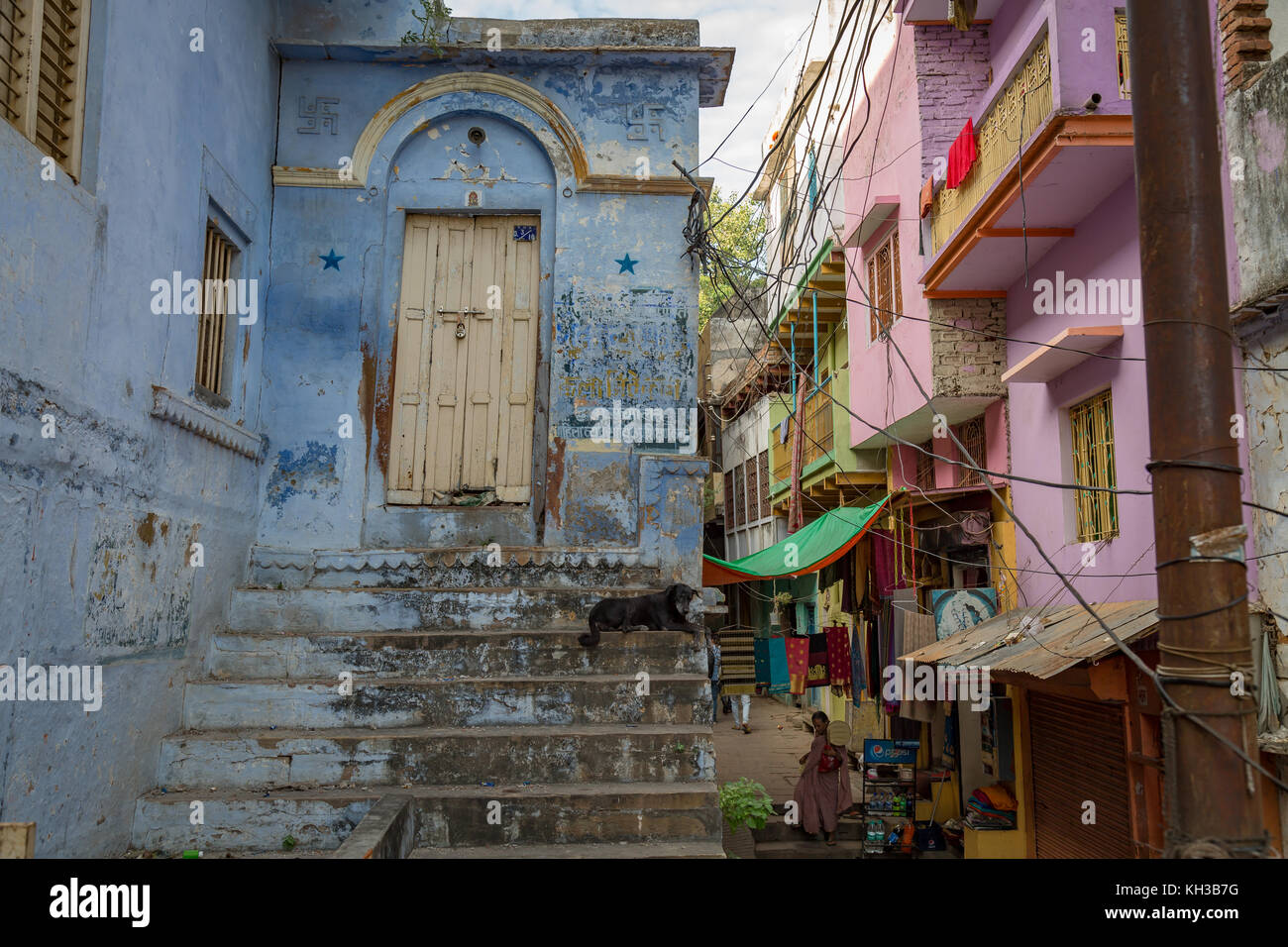 Vecchia città di Varanasi vicoletto con case d'epoca di pareti in mattoni e ripida scalinata. Foto Stock