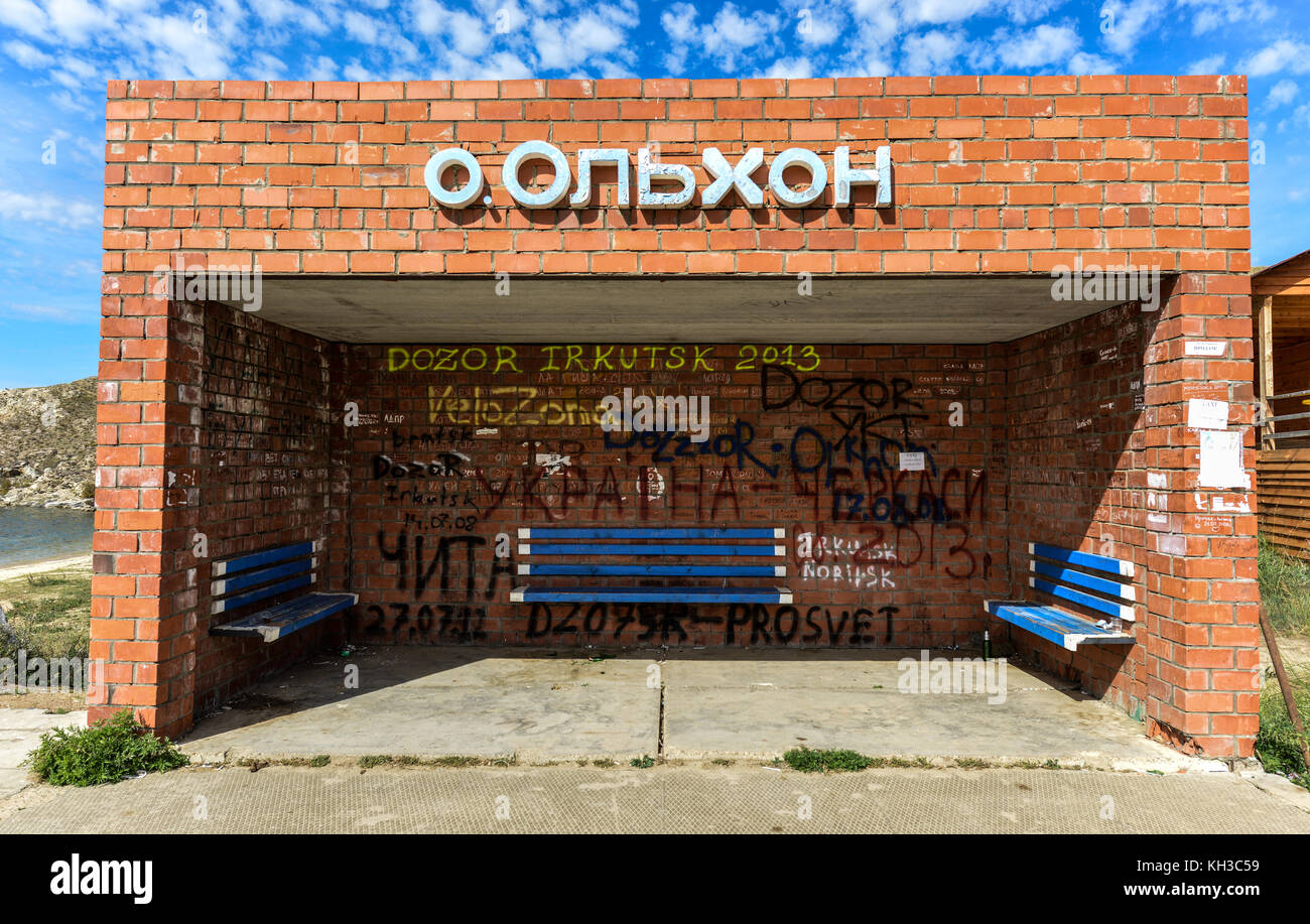 Fermata bus olkhon island SUL LAGO BAIKAL IN RUSSIA. cucciolata tra le panchine di legno e mattoni enclosure. Foto Stock