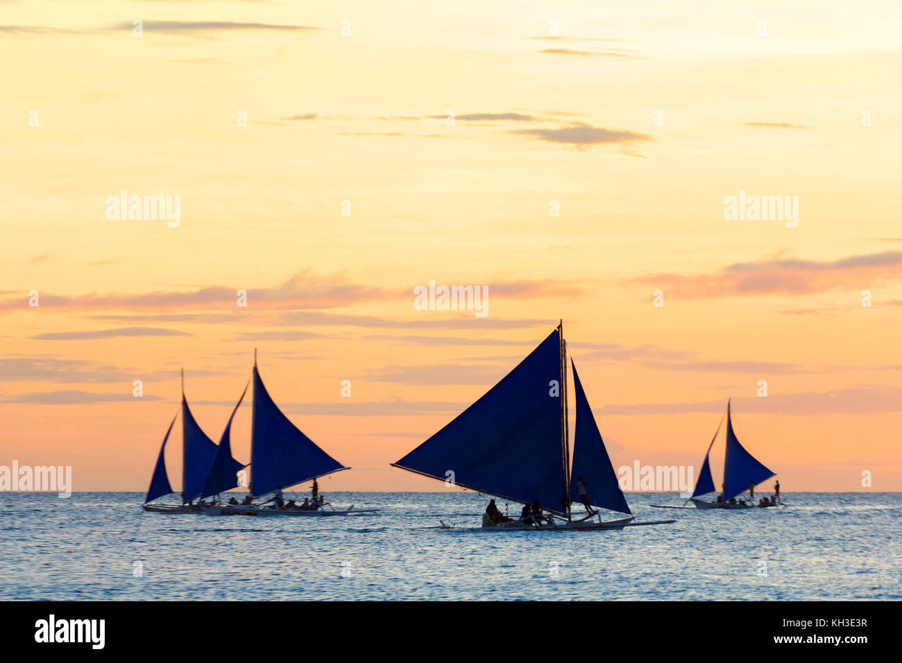 Barche a vela chiamato paraw al tramonto in Boracay Foto Stock