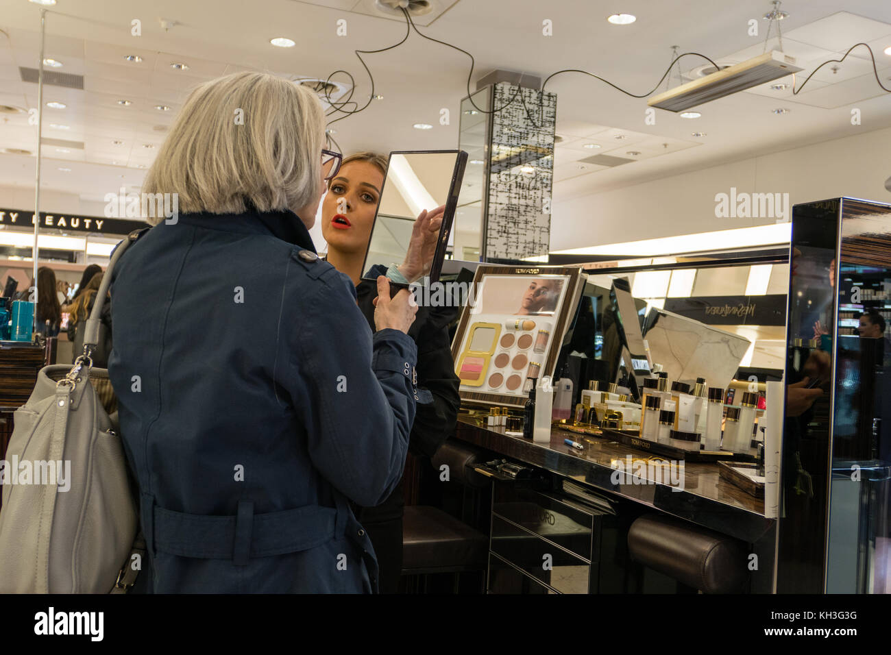 Un cliente che prova i cosmetici in un grande magazzino scozzese Foto Stock
