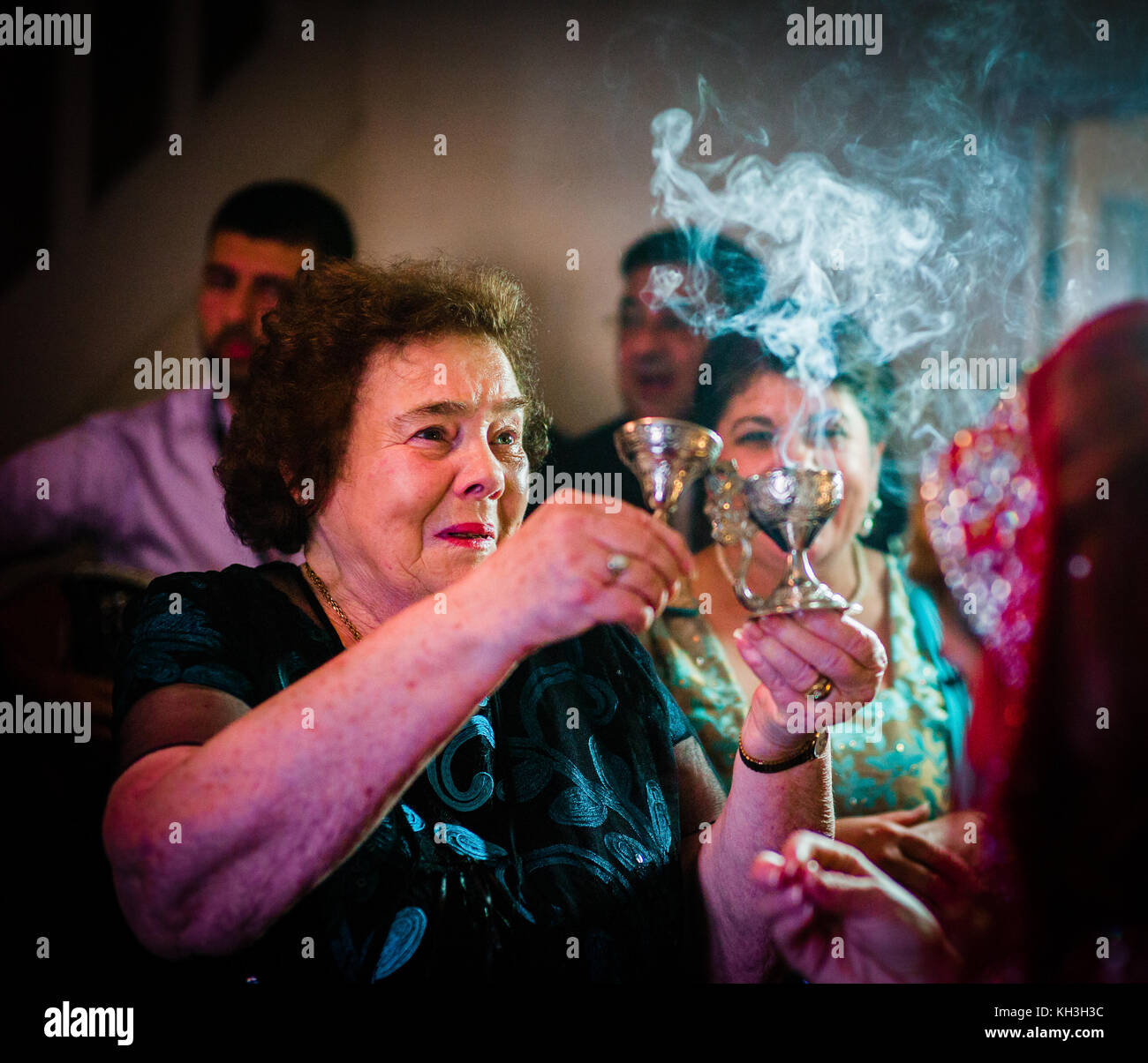 Una nonna brucia incenso davanti a suo nipote sposa nella sua casa durante la tradizionale benedizione della sposa a un cittadino greco-cipriota matrimonio. th Foto Stock