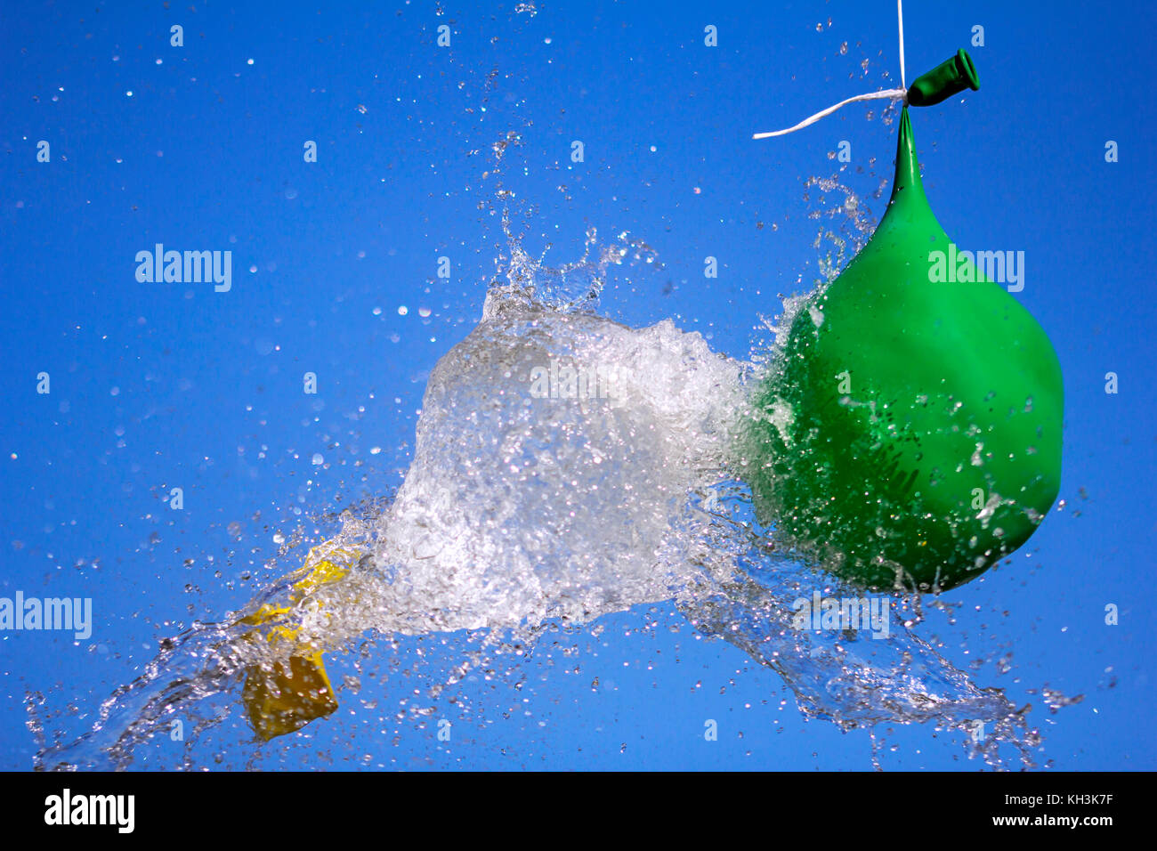 Esplosione di palloncino pieno di acqua su sfondo cielo Foto Stock