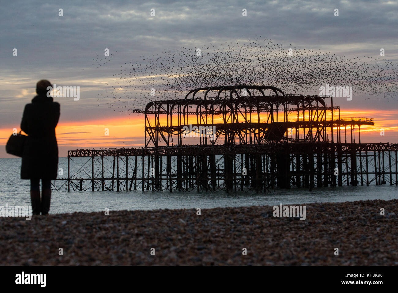 Tramonto a dei derelitti Molo Ovest di Brighton come un gregge di storni, noto come murmuration, mosche tettuccio Foto Stock