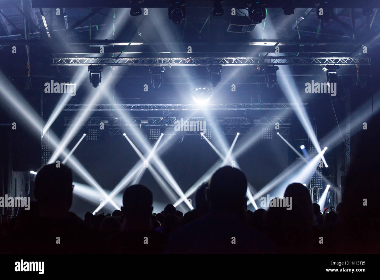 Folla di concerti. Le persone si stagliano davanti alle luci luminose del palco. Gruppo di stelle rock. Foto Stock