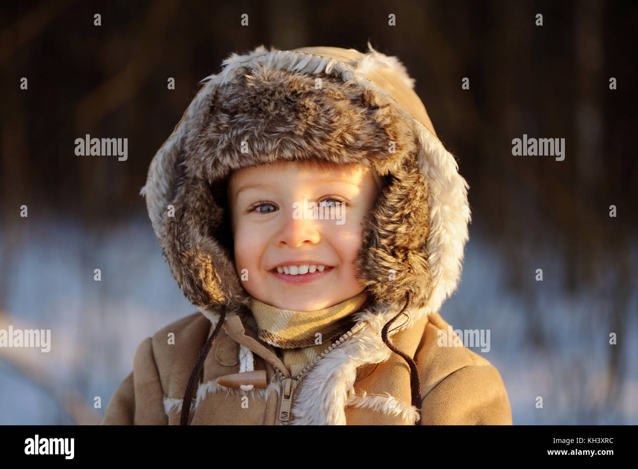 Un ritratto di sorridere, grazioso piccolo bambino ragazzo che indossa il cappuccio di pelle di pecora e il cofano. Chiusura del giovane capretto, guardando la telecamera, felice Foto Stock