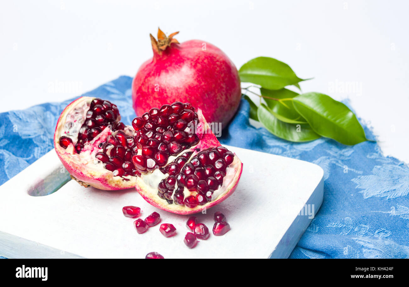 Melograno frutto su un tagliere isolato Foto Stock