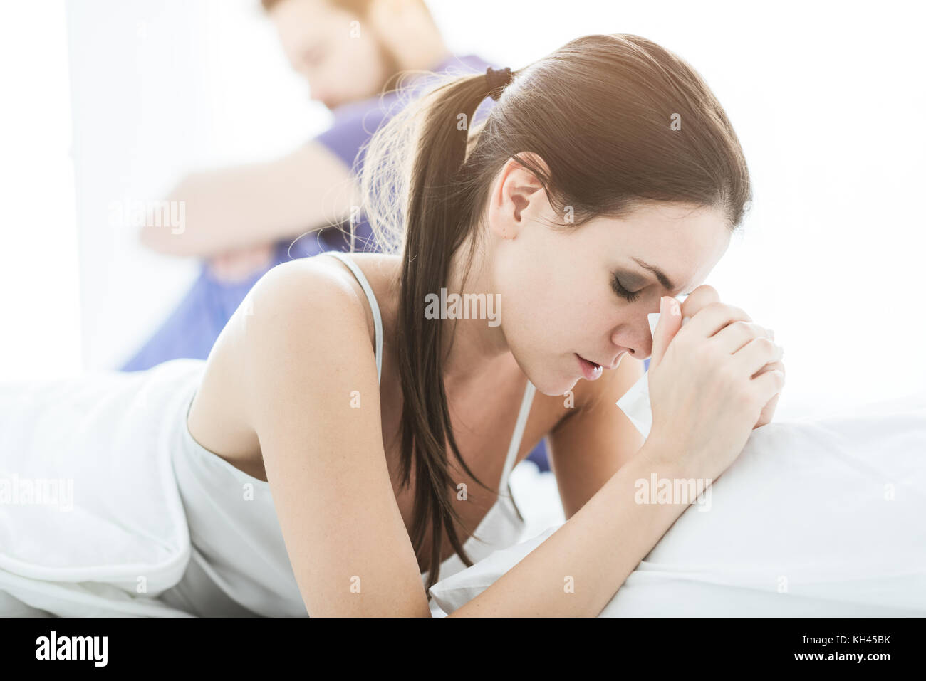 Coppia giovane in camera da letto avente rapporto difficoltà e sostenendo la donna è il pianto Foto Stock