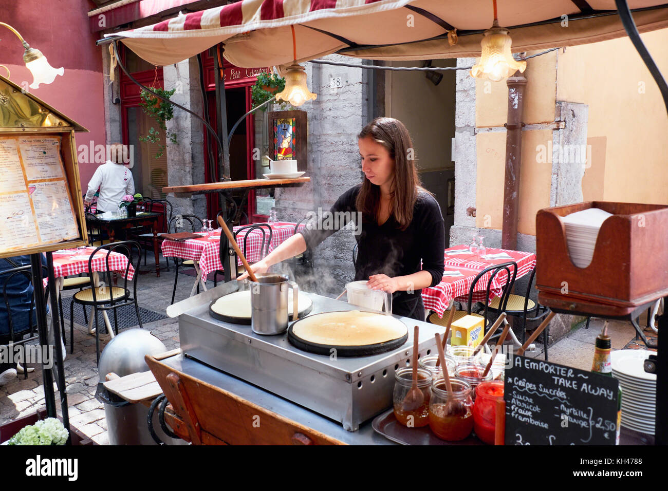 Giovane donna è rendere Crepes all'aperto, Vecchia Lione, Francia Foto Stock