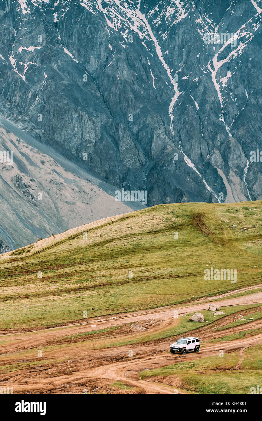 Stepantsminda gergeti, Georgia - 23 maggio 2016: bianco hummer h2 auto suv on off road in primavera Montagne Paesaggio in Georgia. paesaggio della gola a SPR Foto Stock