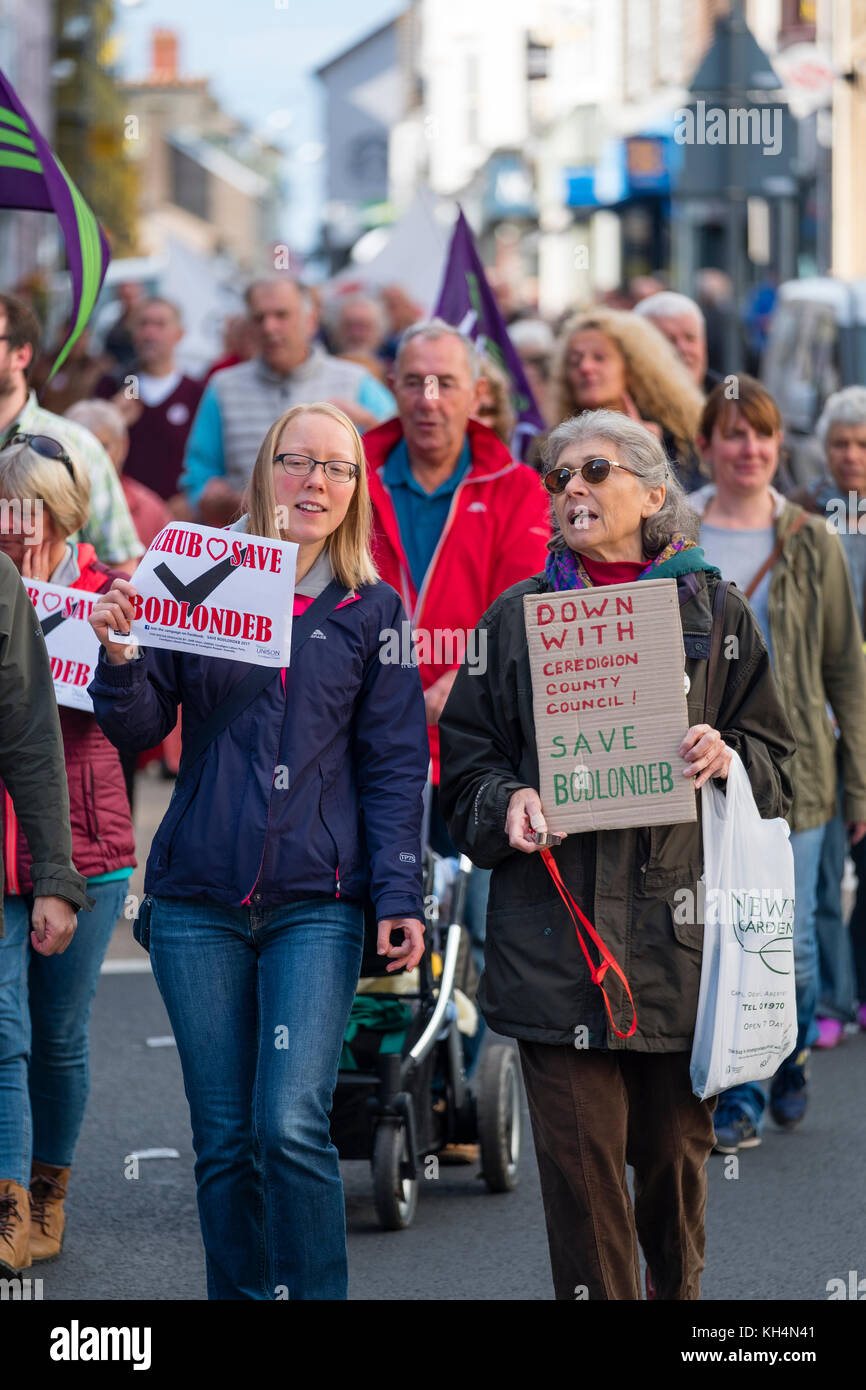 Achub / Salva Bodlondeb marcia di protesta e un gruppo di persone di tutte le età in marcia attraverso le strade di Aberystwyth Wales UK, portante Welsh bilingue Inglese/banner, per protestare contro il Ceredigion County Council piani per chiudere Bodlondeb, il locale la casa di cura per gli anziani, nel suo ultimo round di finanziamento di bilancio tagli. 16 settembre 2017 Foto Stock