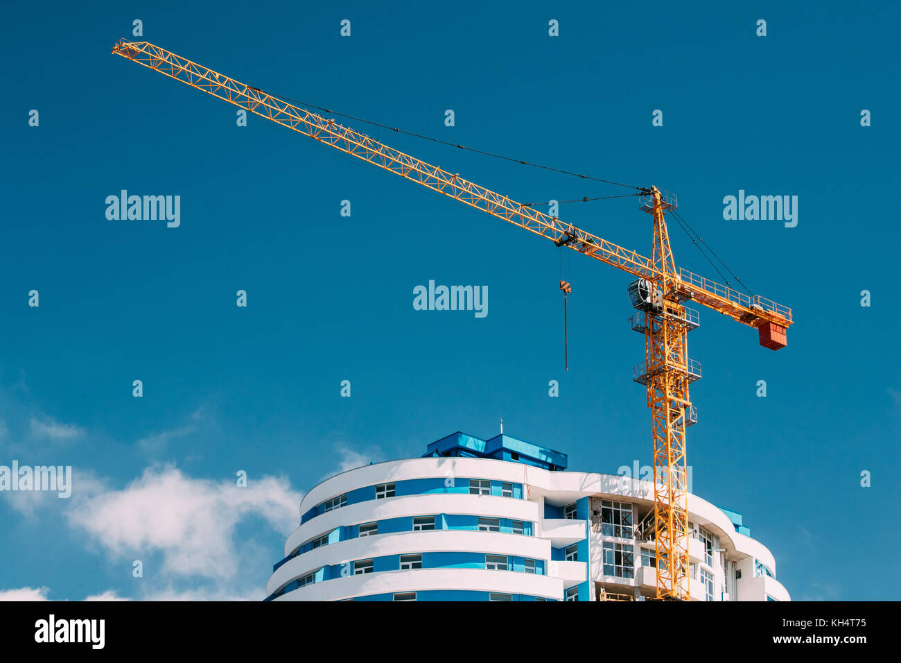 Gru da cantiere è coinvolto nella costruzione di un nuovo multi-storey edificio residenziale. soleggiata giornata estiva. gru da cantiere sullo sfondo di b Foto Stock