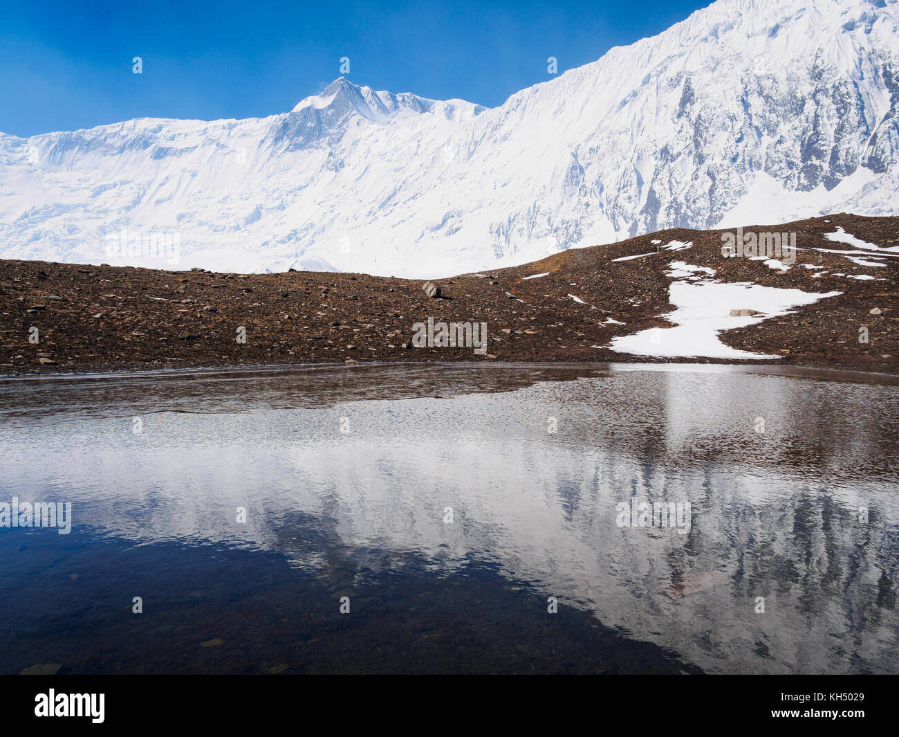 La riflessione della grande barriera mountain range in una piccola tarn vicino tilicho lake, Annapurna Himalaya, Nepal Foto Stock