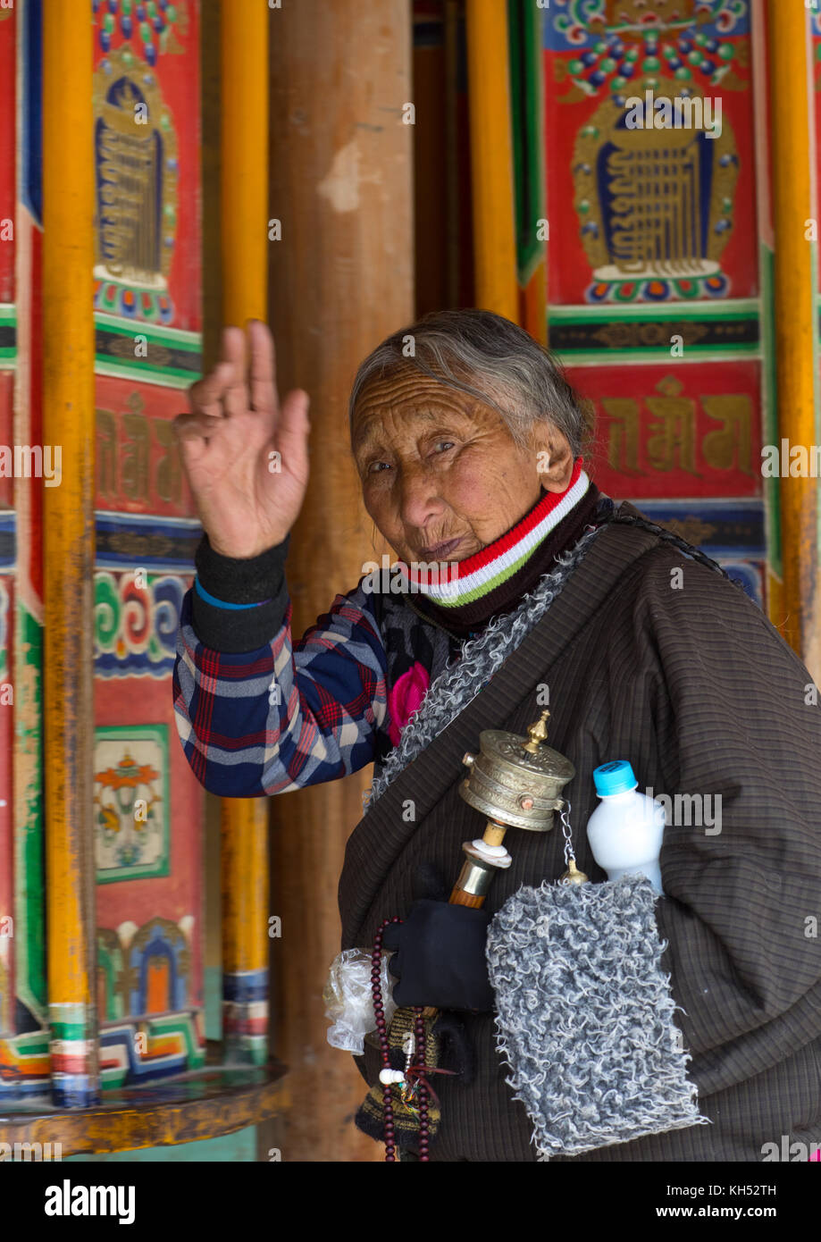 Pellegrino tibetano donna girando enormi ruote della preghiera nel monastero di Labrang, provincia di Gansu, Labrang, Cina Foto Stock