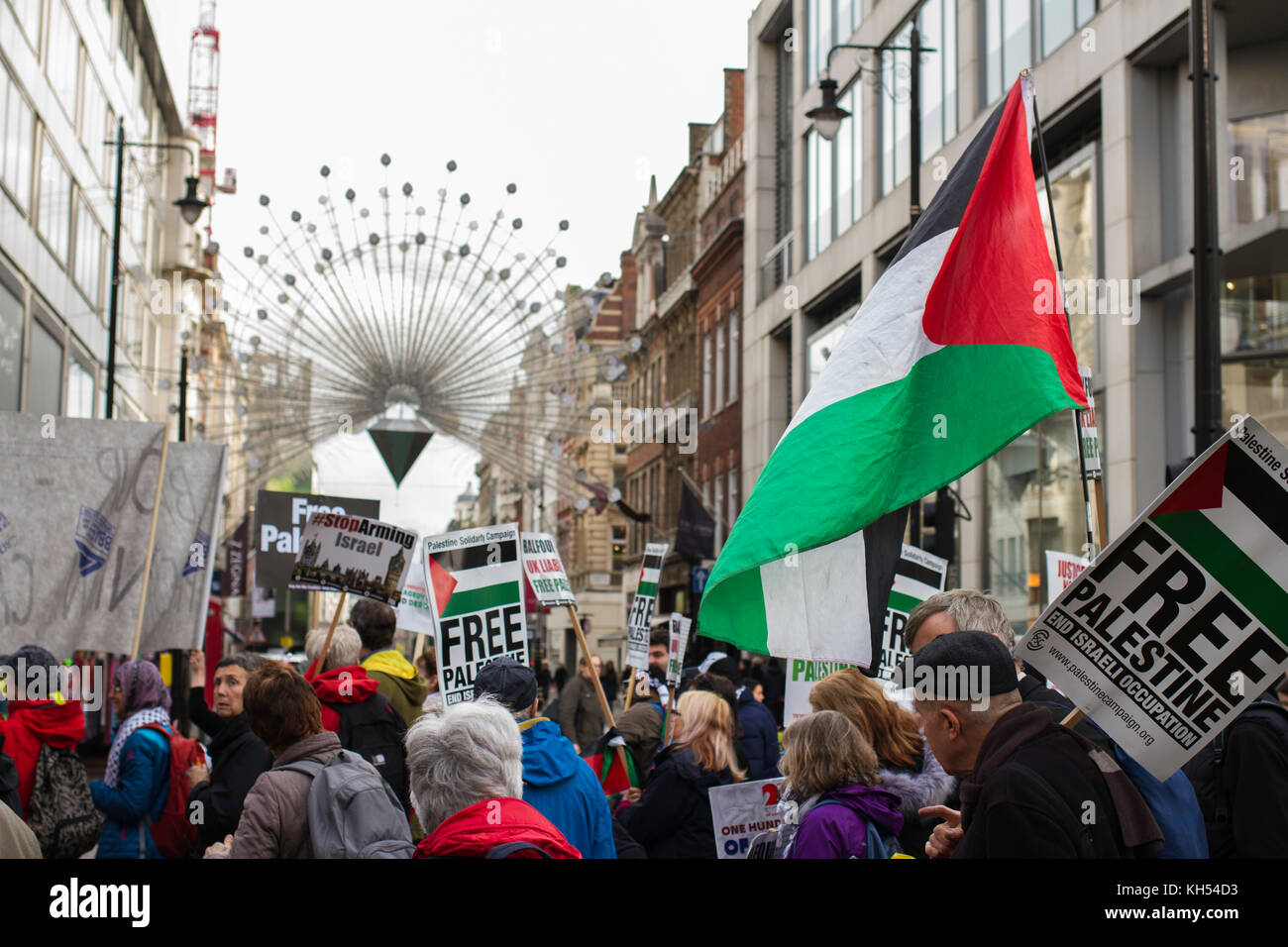 I manifestanti per i diritti palestinesi marciano oltre le luci natalizie di Oxford Street nel centenario della dichiarazione Balfour, Londra Foto Stock