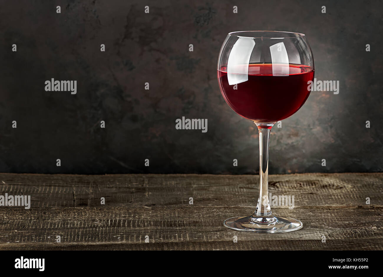 Bicchiere di vino rosso su una tavola di legno Foto Stock