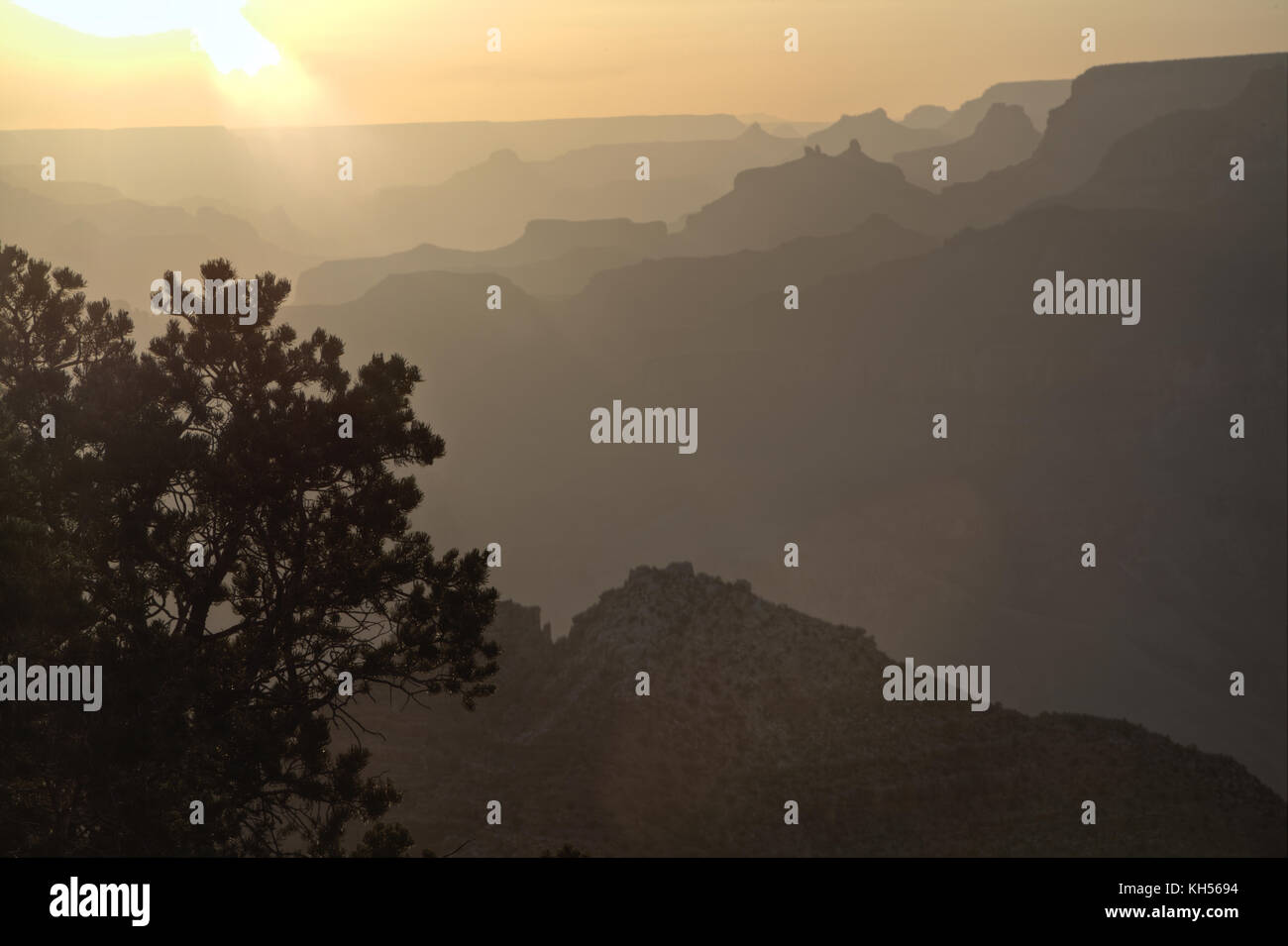 Il Grand Canyon con creste successive delineato contro il sole di setting. Foto Stock