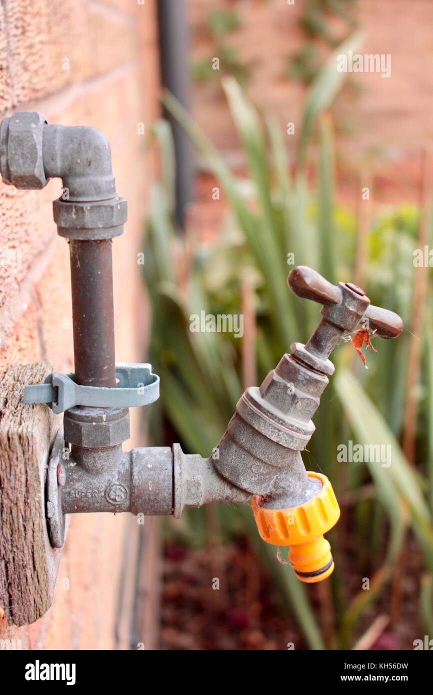 All'aperto il rubinetto dell'acqua sulla parete della cucina con tubo  flessibile giallo connettore collegabile Foto stock - Alamy