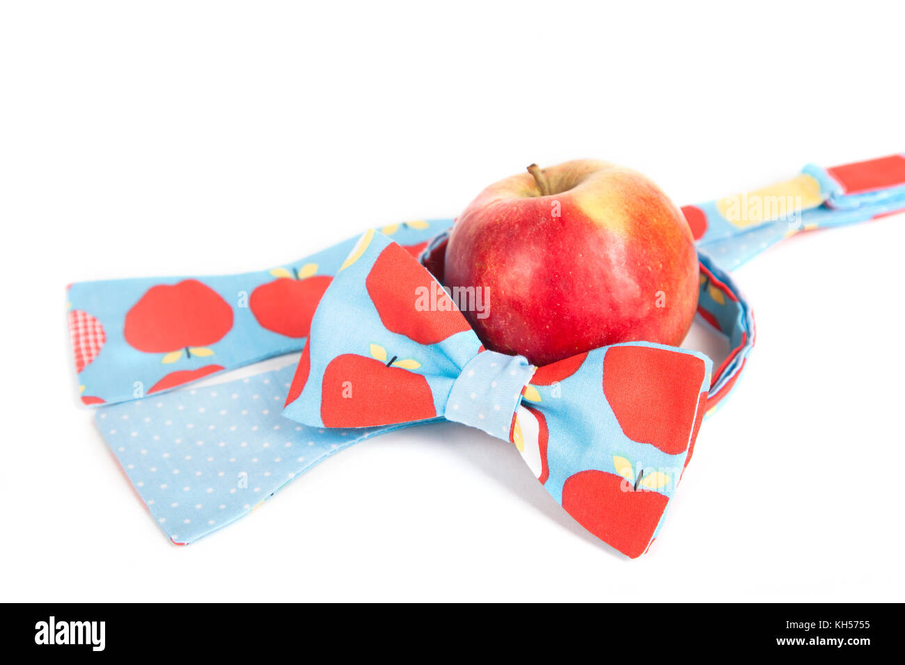 Divertenti bow tie con big red polka dots di fronte red apple, vicino, frutta fresca Foto Stock