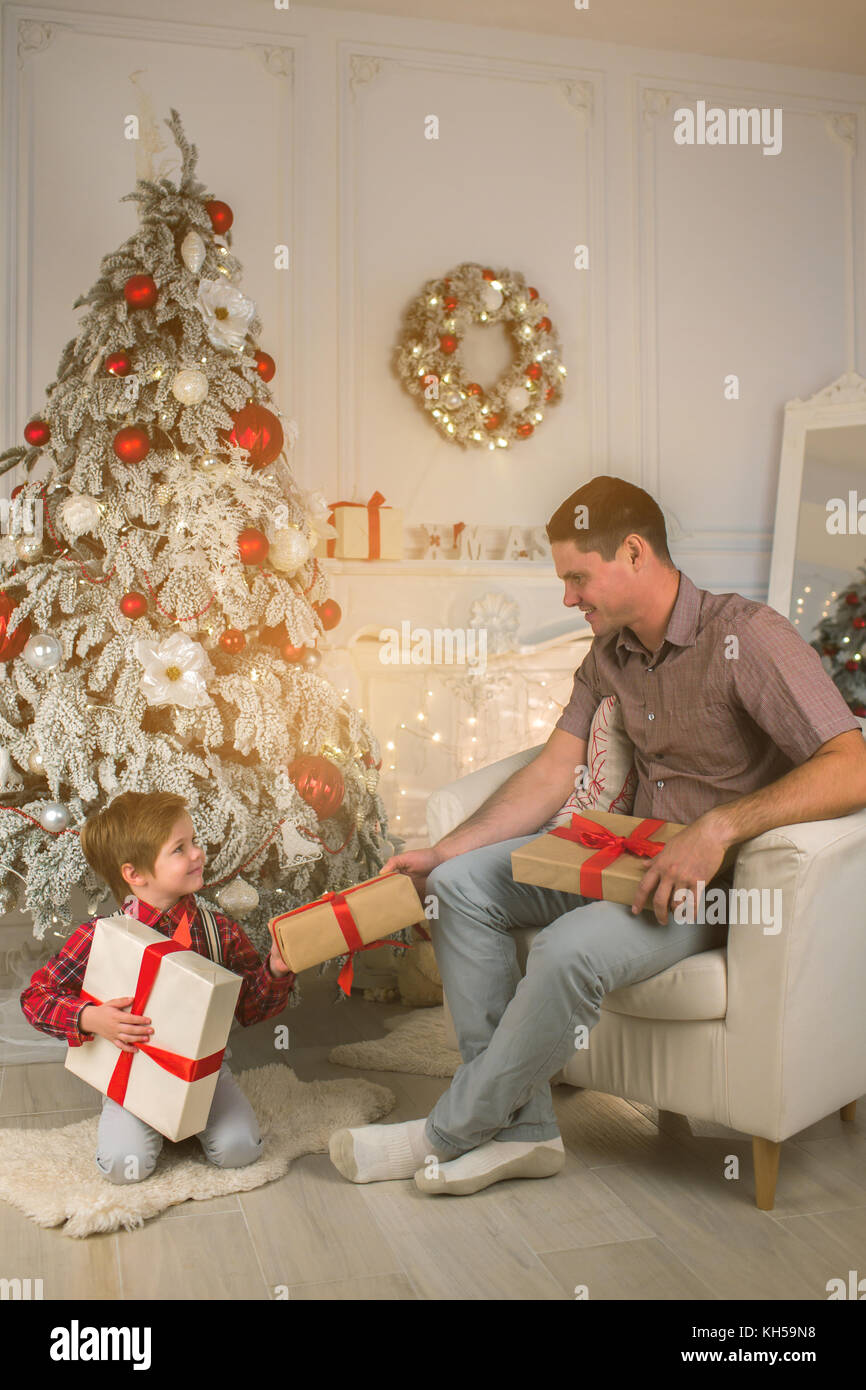 Padre e figlio di unwrapping presenta sulla sera di Natale Foto Stock