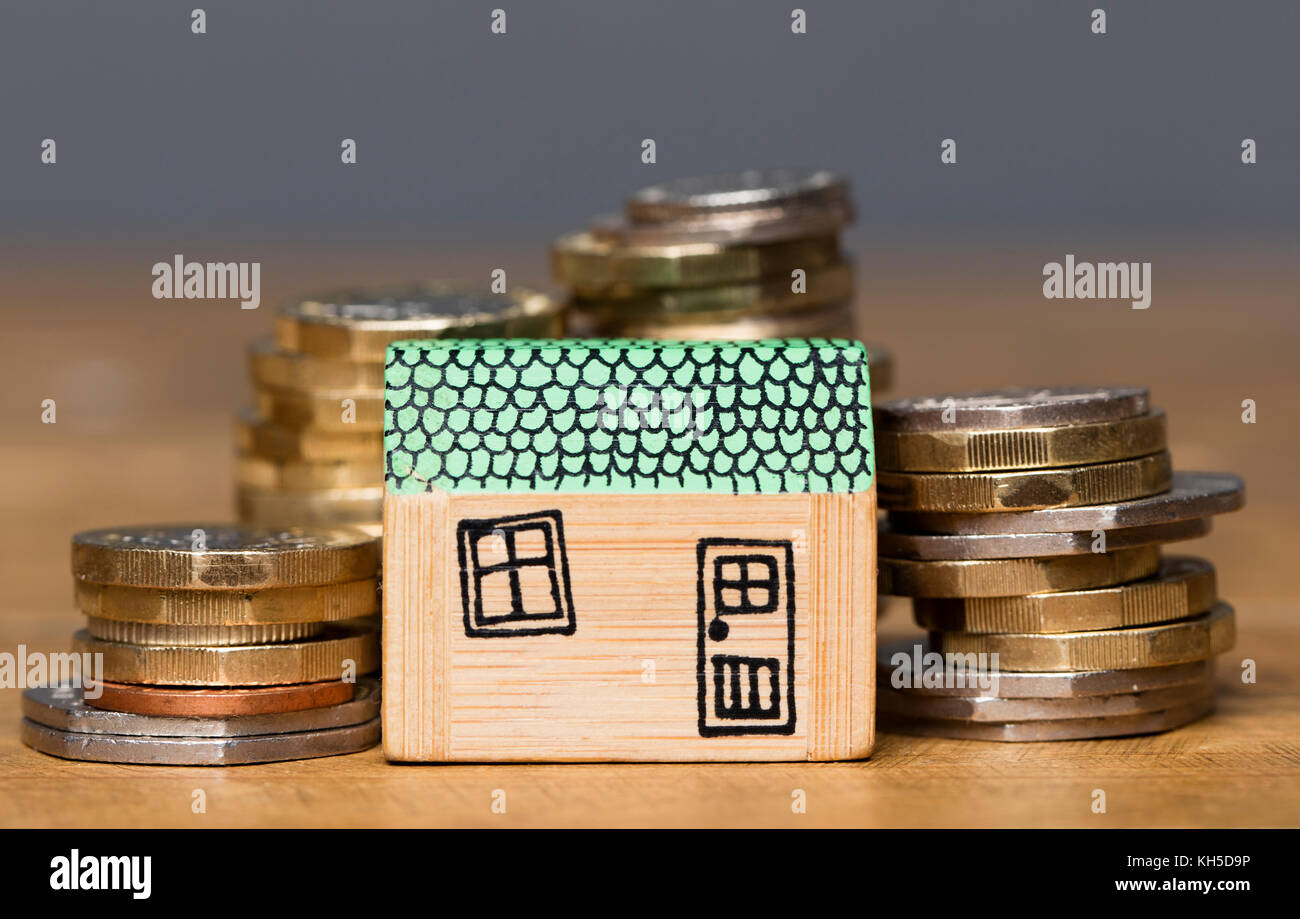Modello di casa con monete. home concetto di finanza Foto Stock