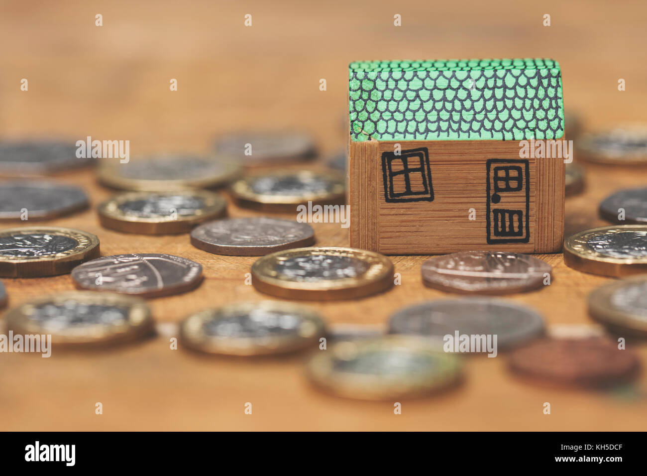 Modello di casa con monete. home concetto di finanza Foto Stock