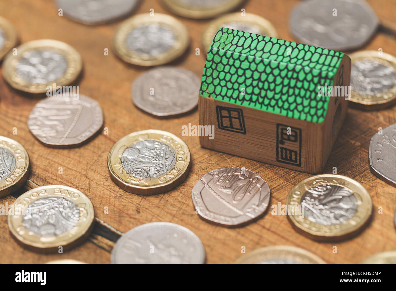 Modello di casa con monete. home concetto di finanza Foto Stock
