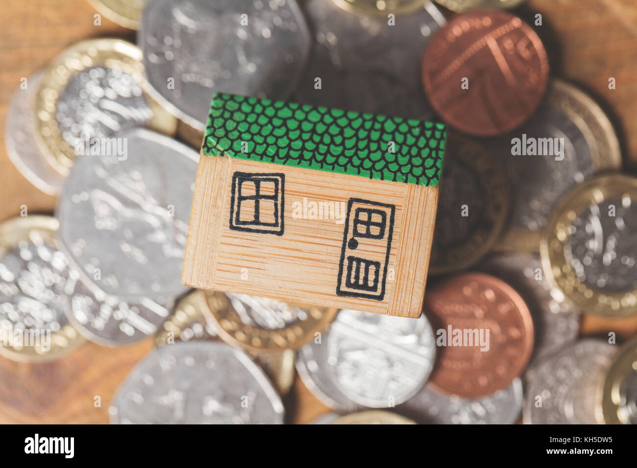 Modello di casa con monete. home concetto di finanza Foto Stock