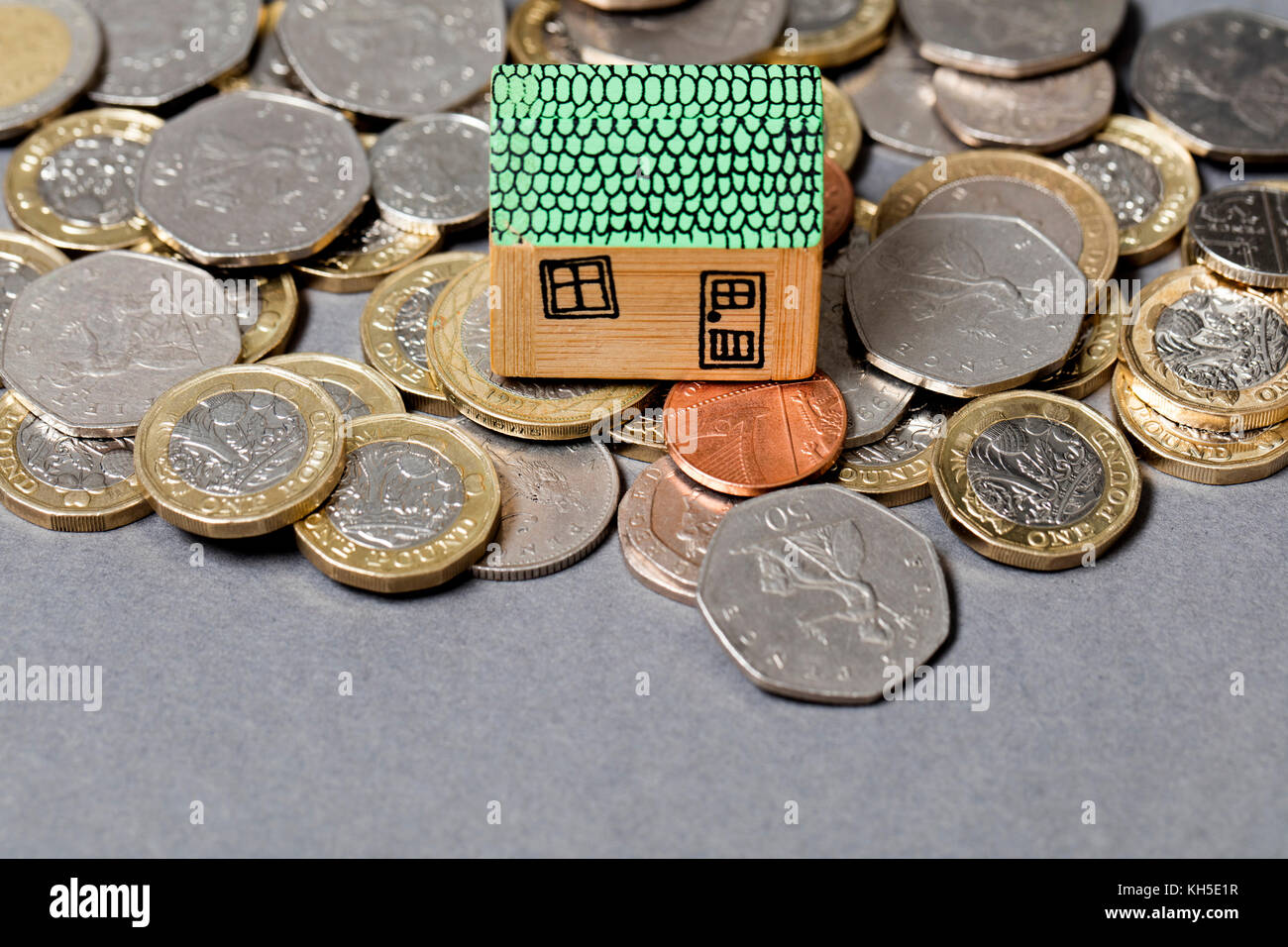Modello di casa con monete. home concetto di finanza Foto Stock