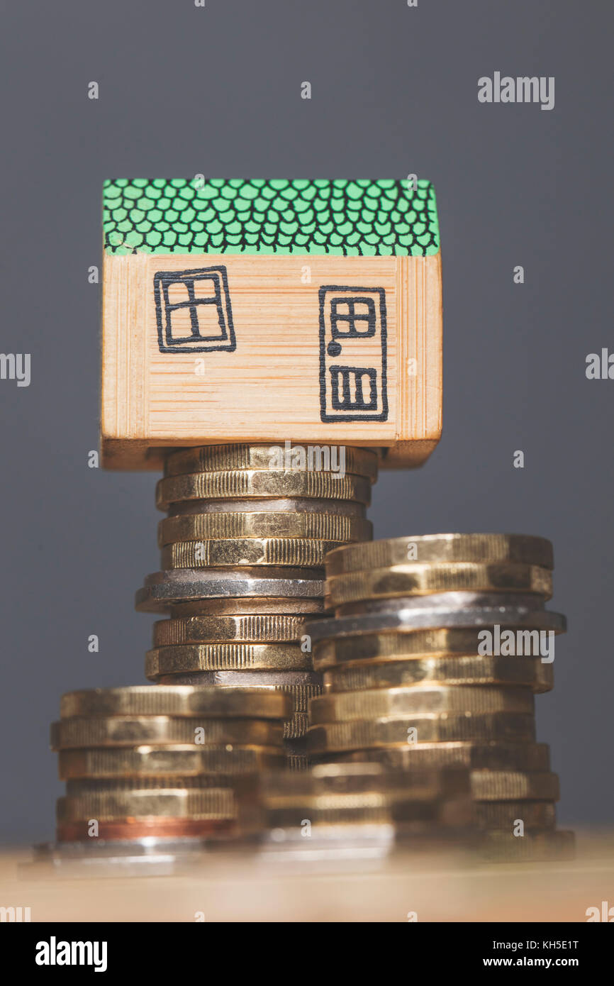 Modello di casa con monete. home concetto di finanza Foto Stock