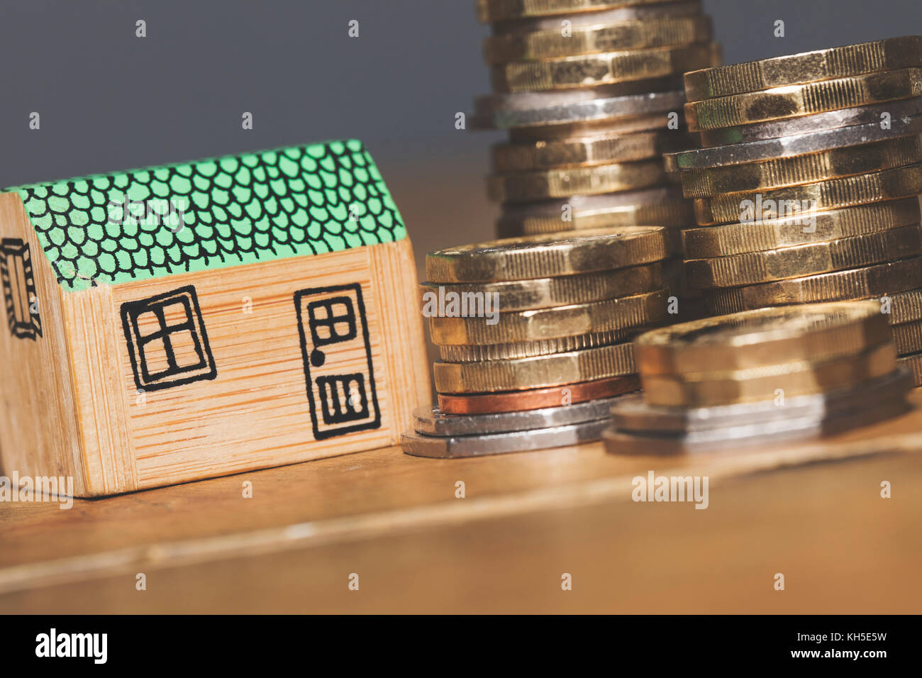 Modello di casa con monete. home concetto di finanza Foto Stock