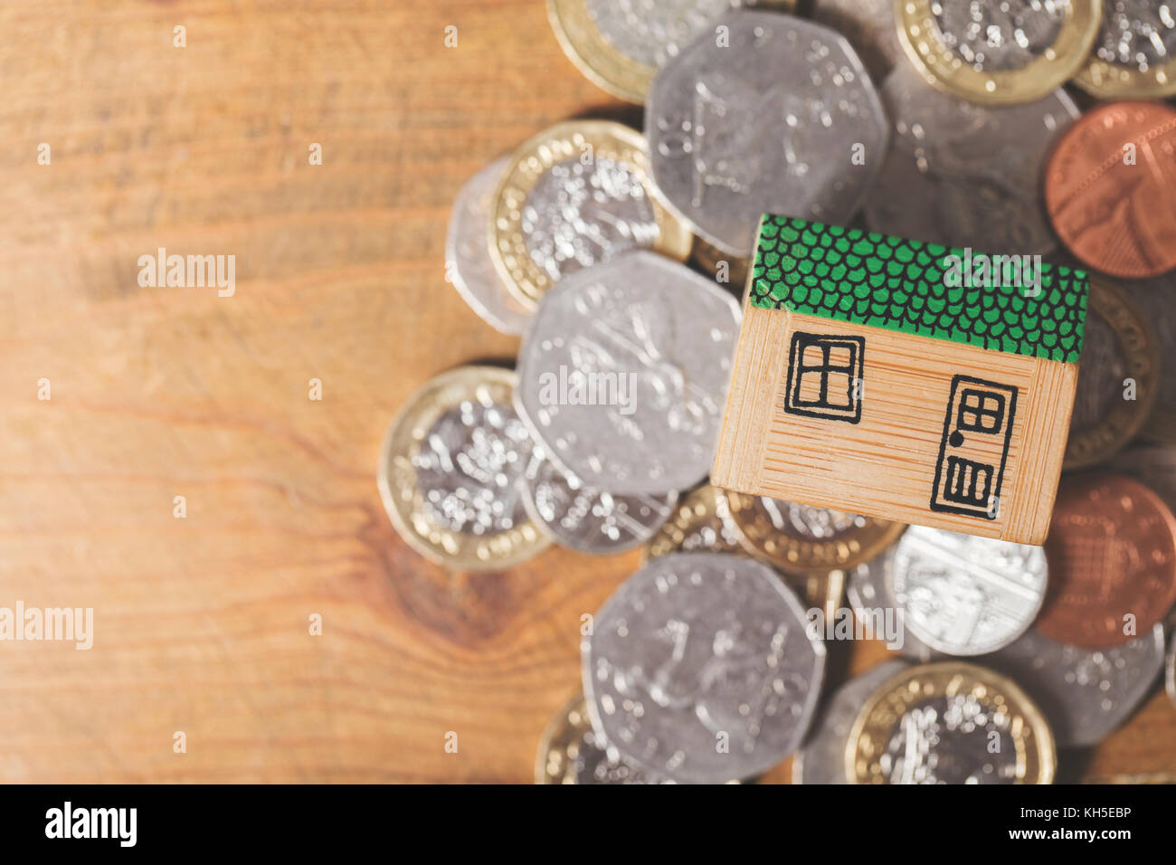 Modello di casa con monete. home concetto di finanza Foto Stock