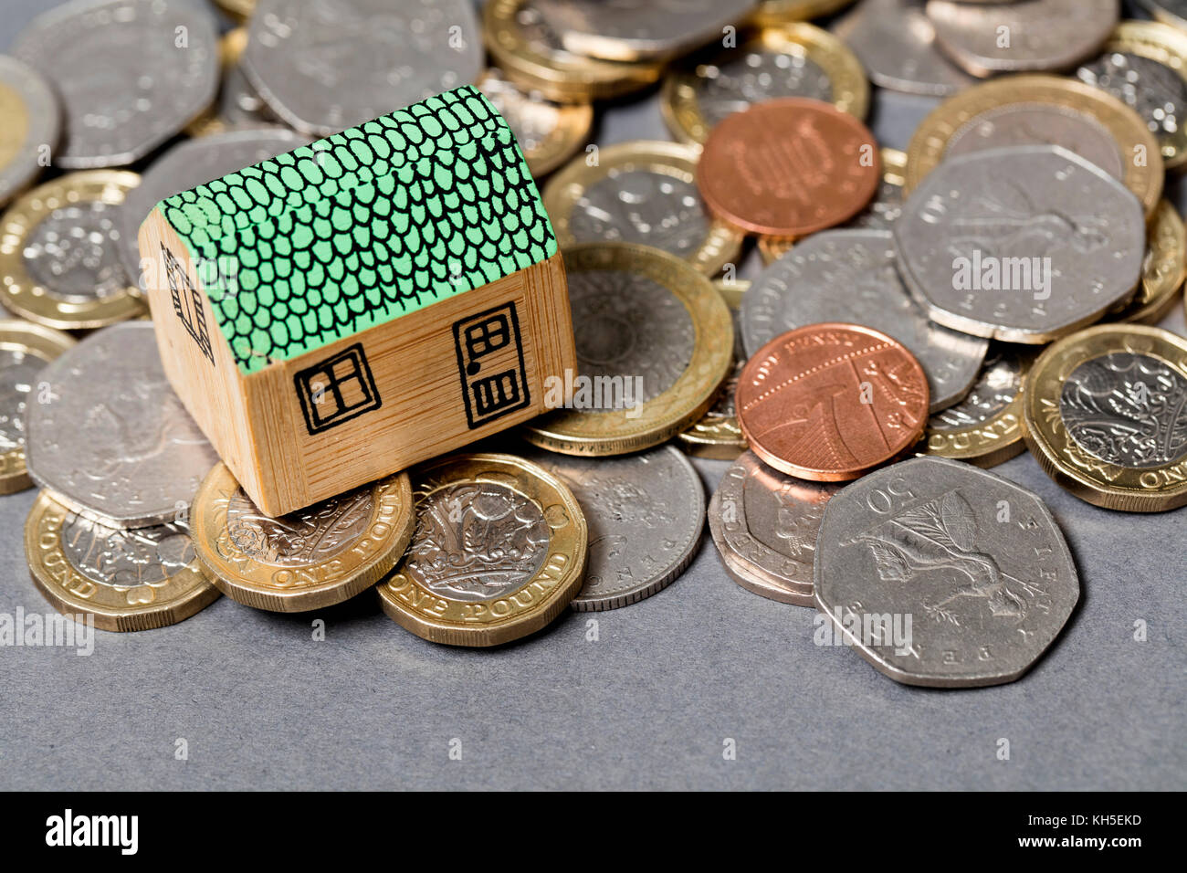 Modello di casa con monete. home concetto di finanza Foto Stock
