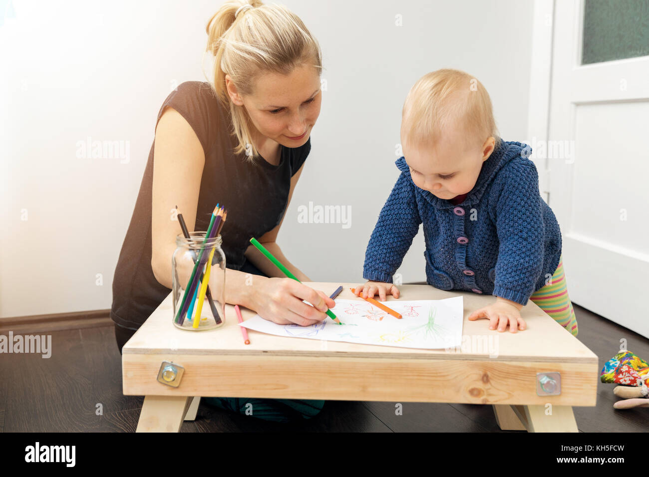 La madre e il bambino di trascorrere del tempo insieme e il disegno di una foto con matite colorate Foto Stock
