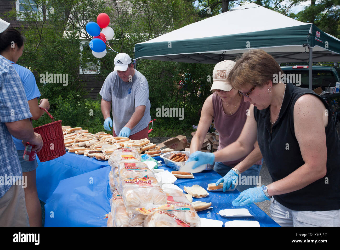 Preparare i lavoratori free hot dogs a quarto di luglio parade udienza a Williamstown nel Massachusetts. Foto Stock